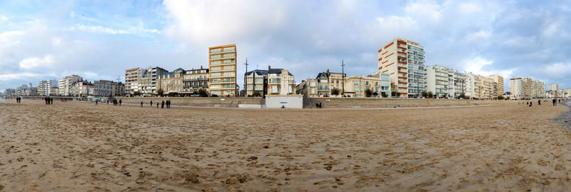 Panoramic view of beach and buildings against sky