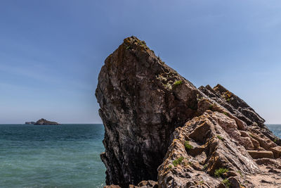 Rock formation in sea against sky