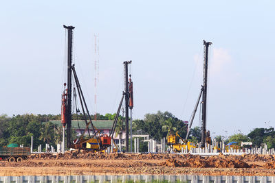 Cranes at construction site against sky