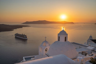 Santorini, white church against colorful sunset in greece