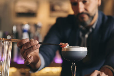 Male bartender preparing cocktail at bar counter