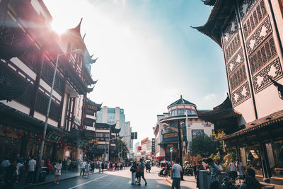 People walking on street amidst buildings in city