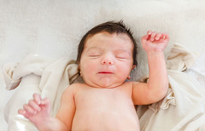 High angle view of cute baby sleeping on bed at home