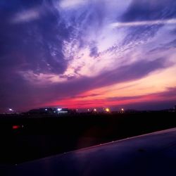 Illuminated city against sky during sunset