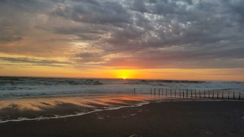 Scenic view of beach against dramatic sky