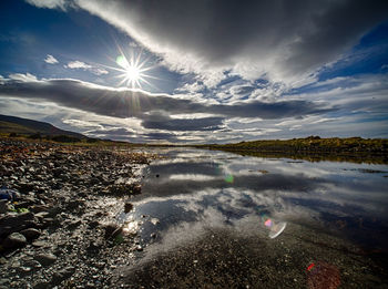 Scenic view of sea against bright sun