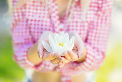 Close-up of woman holding pink rose flower