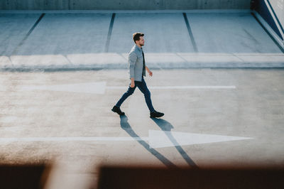 Side view of young man walking in city