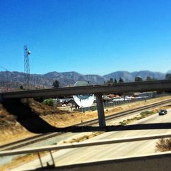 Railroad tracks against clear blue sky