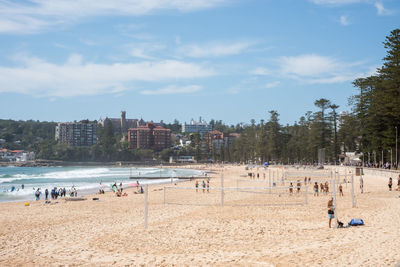 Group of people on beach against sky