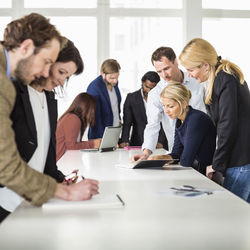 Group of business people working together at desk in office