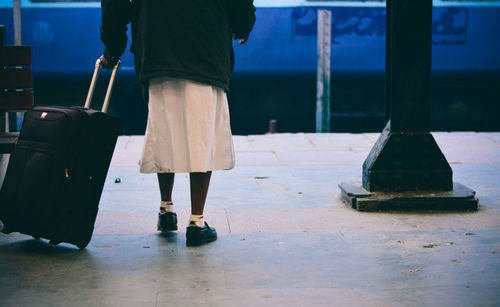 Low section of woman with luggage at railroad station platform