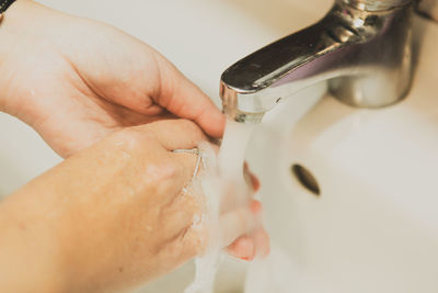 A woman washing her hands in the bathroom at home