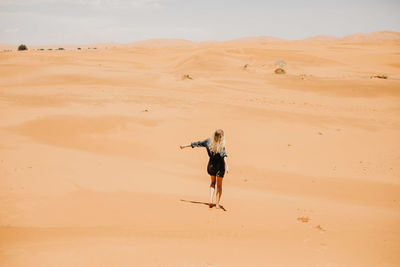 Full length of man on sand dune in desert