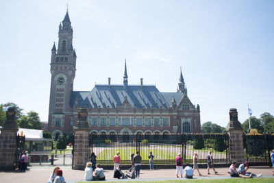 People in front of historic building against sky