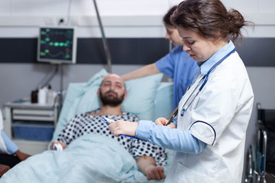 Side view of doctor examining patient in clinic