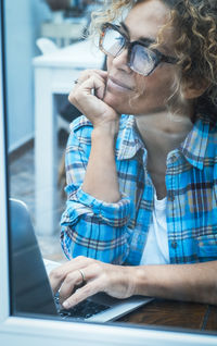 Young woman using mobile phone at table