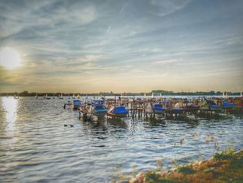 Boats in marina at harbor against sky