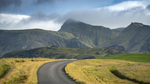 Empty road leading towards mountains in south iceland against sk