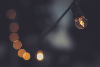 Low angle view of illuminated light bulb at night