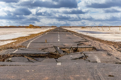 Road amidst land against sky
