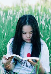 Girl reading book on lawn