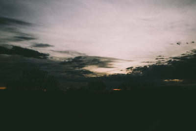 Scenic view of silhouette field against sky at sunset