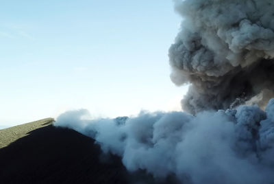Smoke emitting from volcanic mountain against sky