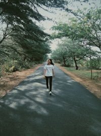 Full length rear view of woman walking on road