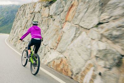 Rear view of person riding bicycle