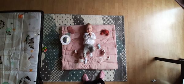 High angle view of cute girl lying on floor at home