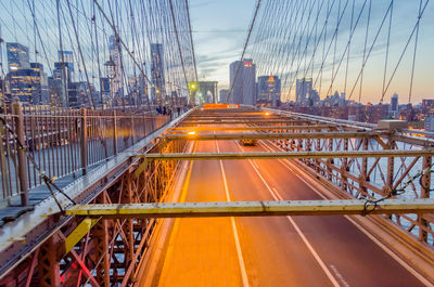 View of suspension bridge in city against sky