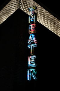 Low angle view of illuminated text against black background