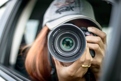 Close-up of man photographing through window