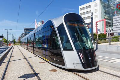 Train on railroad station in city against sky