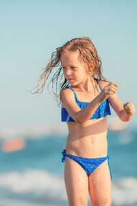 Portrait of young woman standing at beach