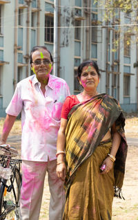 An indian senior couple with colorful faces playing holi - the festival of colors