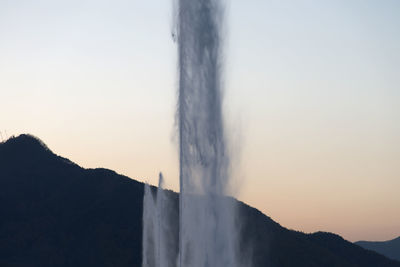 Scenic view of waterfall against sky during sunset