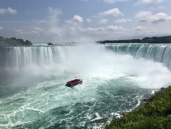 Scenic view of waterfall against sky