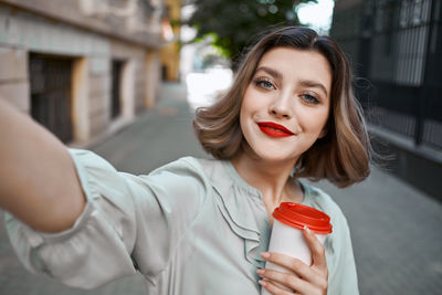 Portrait of beautiful woman holding red outdoors