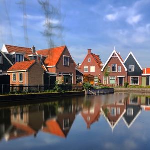 Reflection of buildings in canal against sky