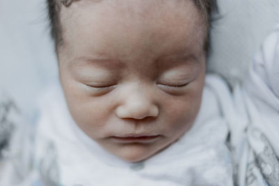 Close-up of baby sleeping on bed