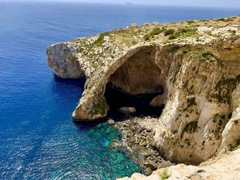 Rock formation in sea against sky