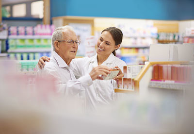 Pharmacist assisting customer at store