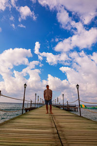 Rear view of man standing on footbridge