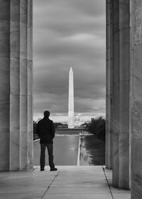 Rear view of man standing in front of historical building