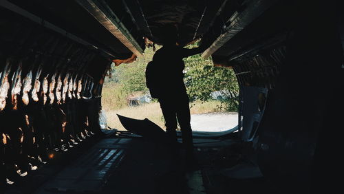 Rear view of silhouette man standing in bus