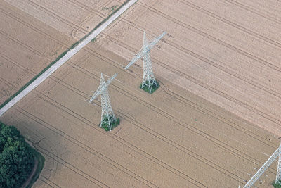 High angle view of electricity pylons on agricultural field