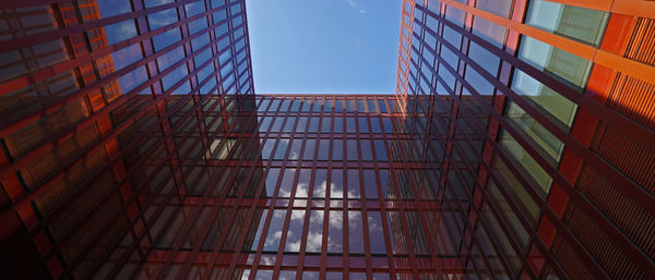 Low angle view of glass building against sky