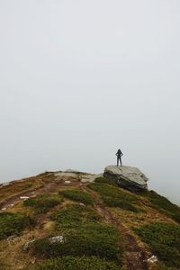 Woman on a rock. its cloudy up in the mountains